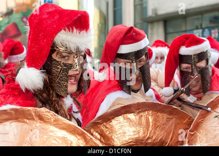 15. Dezember 2012 London UK. Ein Trio von Spartanischer Krieger Santas Roam Londoner Santacon 2012. Die jährliche Feier aller Dinge Weihnachten die Leute verkleidet als Weihnachtsmann als auch Elfen, Rentier und Weihnachtsbäume sieht läuft seit zwölf Jahren. Stockfoto