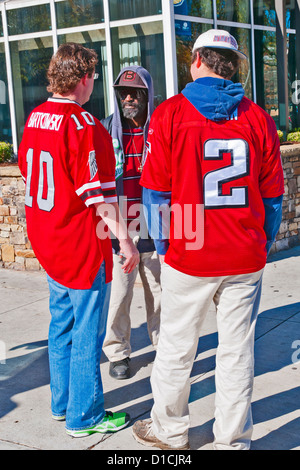 Fußball-Fans in Atlanta Falcons team T-Shorts im Gespräch mit afrikanischen amerikanischen Mann, Atlanta, Georgia, USA Stockfoto