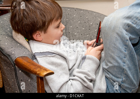 Adsorbiert junge Alter fünf mit Videospielen auf seinem Handheld mobiles elektronisches Gerät. St Paul Minnesota MN USA Stockfoto