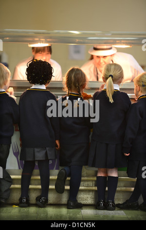 Schulkinder, die Schlange für Toast nach Morgen Versammlung in Our Lady & St. Werburgh's katholische Grundschule in Newcastle-unter- Stockfoto