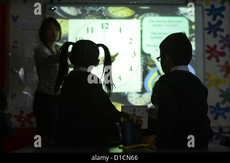 Schülerinnen und Schüler eine Lektion, die in unserer lieben Frau & St. Werburgh's katholische Grundschule in Newcastle-unter-küle Uhrablesen Stockfoto