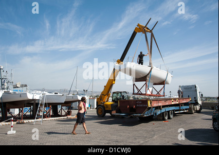 Kran, eine Monotypie J 80 Yacht von einem Tieflader LKW heben verwendet wird. Paphos Hafen Zypern Teil der Flotte Vermietung Yacht Stockfoto