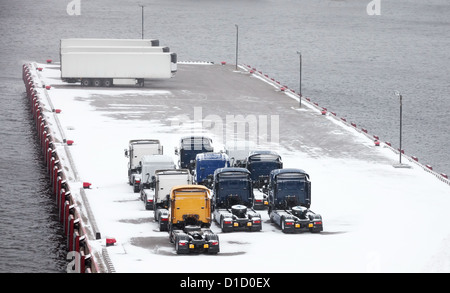 Trucks und Trailer wartet auf verschneiten Pier im Hafen Stockfoto