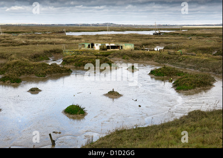 Das Wrack eines verlassenen Hausbootes in der stimmungsvollen Tollesbury Saltings in Essex. Stockfoto