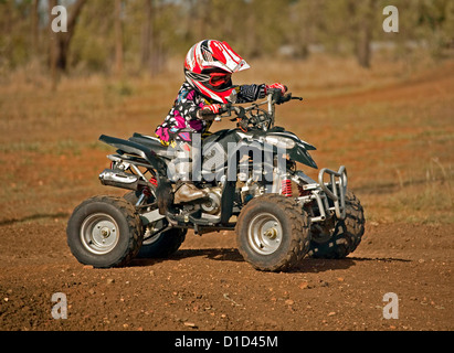 Kleines Kind - im Alter von vier - auf Quad-Bike tragen schützende Kleidung und Reiten auf Feldweg Stockfoto