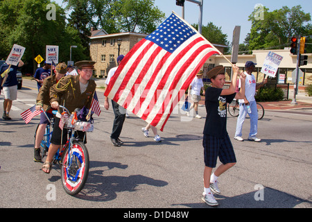 Independence Day Parade 2012 Oak Park (Illinois). Zwei jungen in WWII Uniformen auf dem Fahrrad am Fuß tragen Flagge der Vereinigten Staaten. Stockfoto