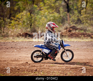 Junge - fünf Jahre alt - tragen von Sicherheitskleidung und auf Motorrad auf Feldweg im Buschland in Australien Stockfoto