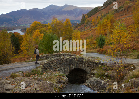 Frau Walker auf Ashness Brücke mit Blick auf Derwentwater und Skiddaw Herbst, The Lake District, Cumbria, England, UK Stockfoto