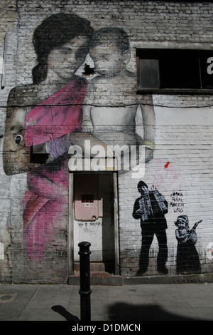 Kunstwerke von Ben Slow (die Frau mit dem Baby) und Jef Aerosol (kleine Schablone Graffiti) Stockfoto