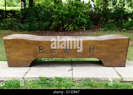 Eine leere Parkbank aus Holz mit der Wortbank im Bellahouston Park in Glasgow, Schottland, Großbritannien Stockfoto