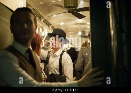 New Yorker, Touristen und u-Bahn Stärkungszauber, einige im historischen Gewand, Reisen auf einem Vintage MTA Nostalgie Zug Weihnachten Saison Fahrt Stockfoto