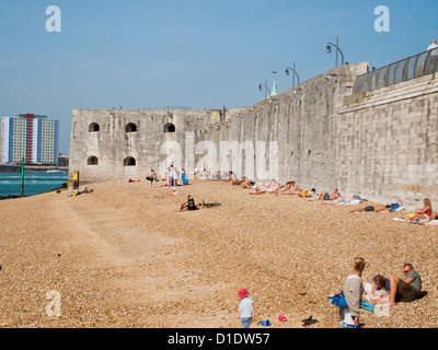 Menschen Sonnenbaden am Strand und neben den heißen Wänden des Portsmouth Harbour Stockfoto