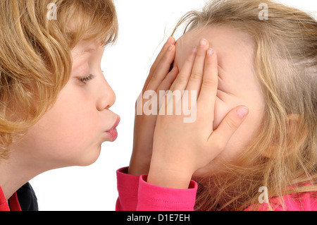 Kleiner Junge, eine Mädchen in weißen isoliert zu küssen versucht Stockfoto