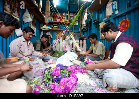 Mala Entscheidungsträger (Girlande Hersteller) auf arbeiten in Kolkata Morgen Blumenmarkt, Howrah, Kalkutta, Westbengalen, Indien, Asien Stockfoto