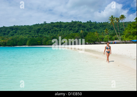 Touristische Wanderung entlang der türkisblauem Wasser und weißem Sand am Champagner Strand, Insel Espiritu Santo, Vanuatu, Südpazifik Stockfoto