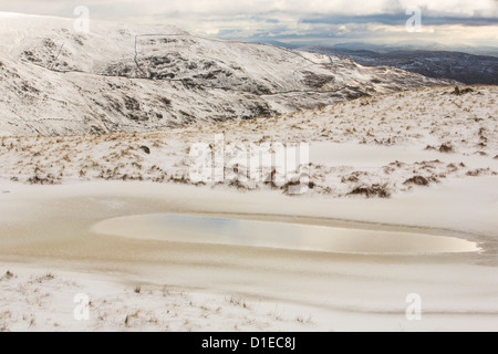 Eisigen Temperaturen auf Fairfield in nebligen Wetter mit Schneeverwehungen bei starkem Wind, Lake District, Großbritannien. Stockfoto