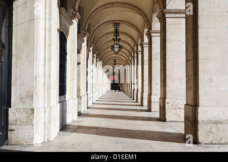 Gewölbte Decke mit kunstvollen Eisenlampen, die im Gang im Innenhof hängen Stockfoto