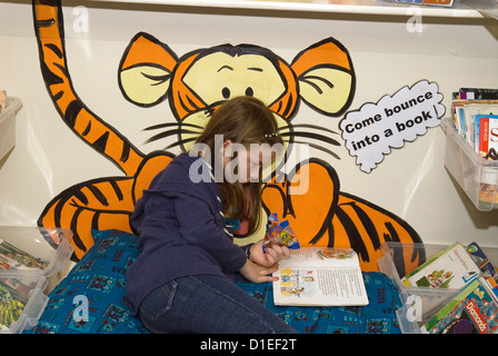 7-Jähriges Mädchen lesen Buch bei Junior School, Hampshire, UK. Stockfoto