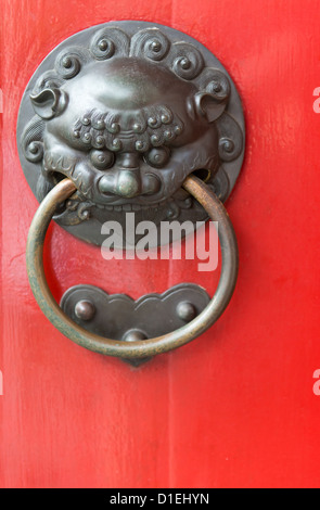 Alte rote chinesische mit dekorativen Metall Türgriff, selektiven Fokus auf das Gesicht vorne Stockfoto