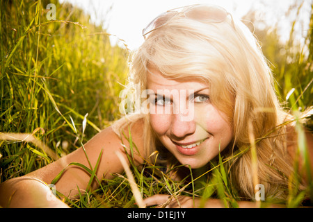 Junge Frau in langen Rasen liegen Stockfoto
