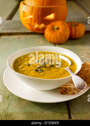 & Speck Kürbis-Suppe mit einem traditionellen Haloween-Kürbis mit einem geschnitzten Gesicht Stockfoto