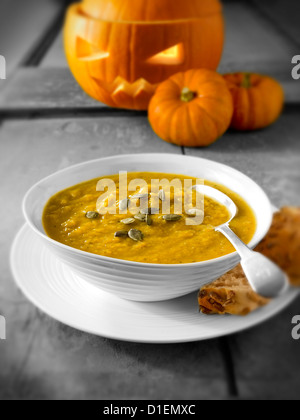 & Speck Kürbis-Suppe mit einem traditionellen Haloween-Kürbis mit einem geschnitzten Gesicht Stockfoto