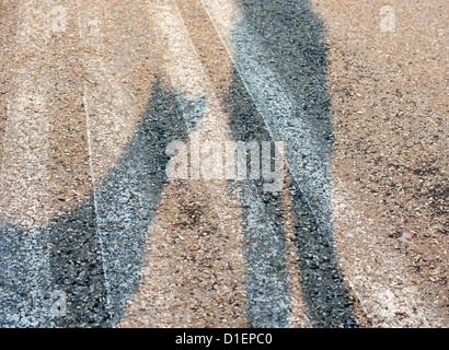 Ein Hund seinen Besitzer, als ihre zwei angrenzenden Schatten geworfen auf dem Bürgersteig blickte. Stockfoto