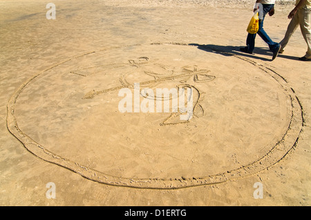 Horizontale Ansicht von 'Om' geschrieben in den Sand am Strand von Varkala, Kerala reinwaschen. Stockfoto