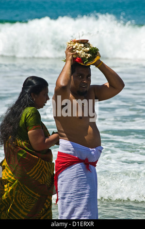 Vertikale Porträt von einem indischen Mann und Frau Puja (Gebete) am Strand von Varkala, Kerala durchführen. Stockfoto