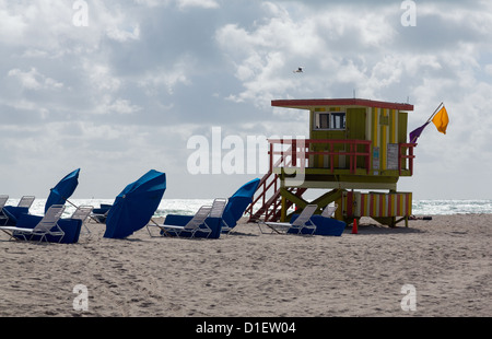 Gelbe und grüne Strandwache auf Miami Beach Florida mit Sonnenschirmen und liegen Stockfoto