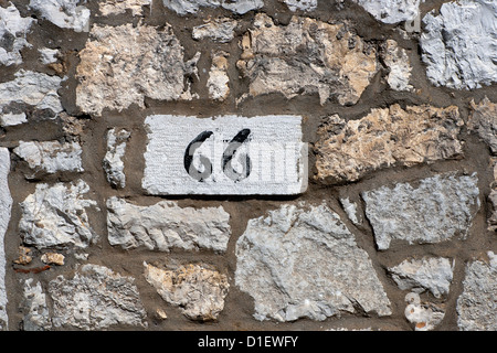 Nummer 66 auf der Steinmauer Stockfoto