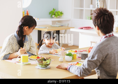 Jungen Erwachsenen paar und ihre Tochter in ihrem Speisesaal frühstücken Stockfoto