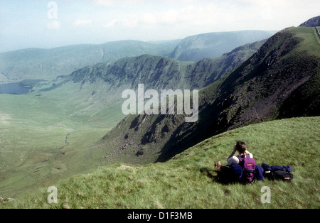 Eine weibliche fiel-Walker-Vogelbeobachtung auf Dale Head, mit Blick auf Riggindale im Lake District. Stockfoto