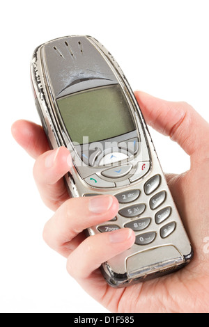 Eine alte veraltete abgenutzt sein Handy über weiß gehalten Stockfoto