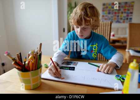 Ein kleiner Junge ist eine Liste von wünschen für Weihnachten schreiben. Stockfoto
