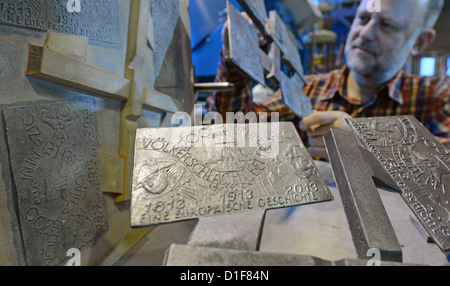 Testen Gebietsdirektor der Gießerei der Freiberger Universität für Bergbau und Technologie, Uwe Nitsch, Examens die Besetzung zum Jubiläum der Völkerschlacht in Freiberg (Sachsen), Deutschland, 18. Dezember 2012 Medaille. Die Medaillen für den 200. Jahrestag der Schlacht bestehen aus Kanonenkugeln von 1813 fanden auf den Schlachtfeldern um Leipzig. Zunächst ist es eine limitierte Auflage von 600 Medaillen. Foto: Hendrik Schmidt Stockfoto