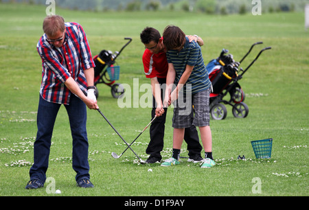 Golf-Trainer David Lang zeigt 12-Year-Old Max, wie Sie während einer Übung auf dem Golf Platz Warnemünde Diedrichshagen, Deutschland, 28. Juni 2012 abschlagen. Die Anzahl der Golftouristen in Deutschland wird kontinuierlich erhöht. Foto: Jens Büttner Stockfoto