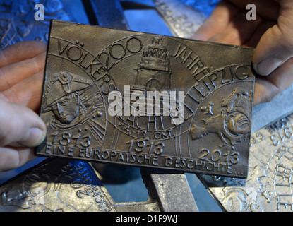 Angestellter der Gießerei der Freiberger Universität für Bergbau und Technologie Examens Medaille die Besetzung für den Jahrestag der Völkerschlacht in Freiberg (Sachsen), Deutschland, 18. Dezember 2012. Die Medaillen für den 200. Jahrestag der Schlacht bestehen aus Kanonenkugeln von 1813 fanden auf den Schlachtfeldern um Leipzig. Zunächst ist es eine limitierte Auflage von 600 Medaillen. Foto: Hendrik Schmidt Stockfoto