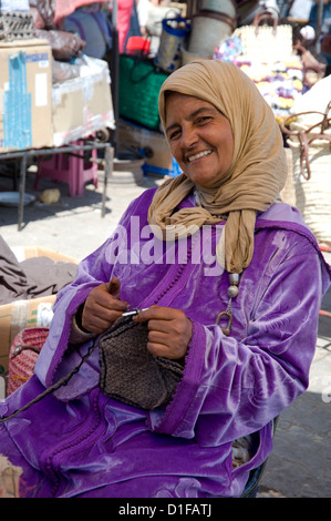 Eine Frau in traditioneller Kleidung stricken Wollmützen am Souk, Marrakesch, Marokko, Nordafrika, Afrika Stockfoto