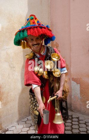 Ein Wasser-Verkäufer in bunten Berber Tracht gekleidet in Marrakesch, Marokko, Nordafrika, Afrika Stockfoto