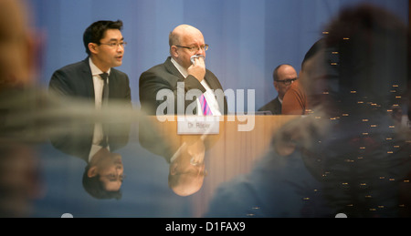 German Environment Minister Peter Altmaier (R) und Wirtschaftsminister Philipp Roesler geben eine Pressekonferenz in Berlin, Deutschland, 19. Dezember 2012. Diese Woche Kabinettssitzung konzentrierte sich auf die Ausweitung der das Stromnetz. Foto: HANNIBAL HANSCHKE Stockfoto