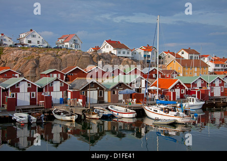 Bunten traditionellen Fischerhütten und Bootshäuser mit Booten entlang Holzmole im Smögen, Bohuslän, Schweden, Scandinavia Stockfoto