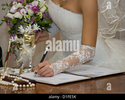 Braut setzt Unterschrift auf dem Dokument Stockfoto