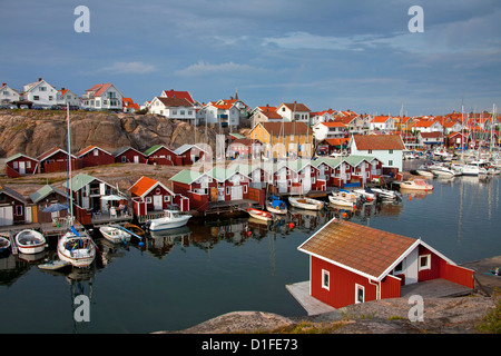 Bunten traditionellen Fischerhütten und Bootshäuser mit Booten entlang Holzmole im Smögen, Bohuslän, Schweden, Scandinavia Stockfoto