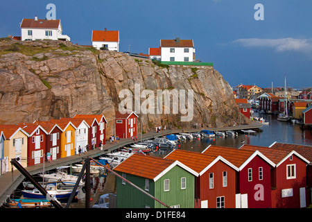 Bunten traditionellen Fischerhütten und Bootshäuser mit Booten entlang Holzmole im Smögen, Bohuslän, Schweden, Scandinavia Stockfoto