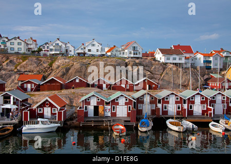 Bunten traditionellen Fischerhütten und Bootshäuser mit Booten entlang Holzmole im Smögen, Bohuslän, Schweden, Scandinavia Stockfoto