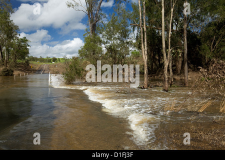 Wasser von Überschwemmungen Fluß über konkrete Damm der Landstraße Stockfoto