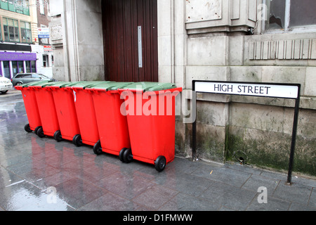 Rot-Mülleimer-Wheelie auf der Straße in Newport, South Wales, UK Dezember 2012 Stockfoto