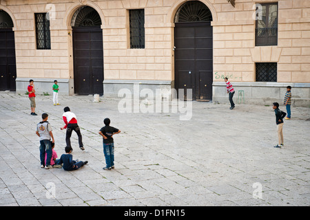 Bangladeshi migrantische Jungs spielen Cricket an einem Platz im alten Palermo, Italien Stockfoto