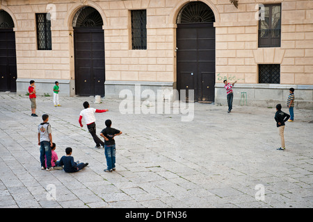 Bangladeshi migrantische Jungs spielen Cricket an einem Platz im alten Palermo, Italien Stockfoto